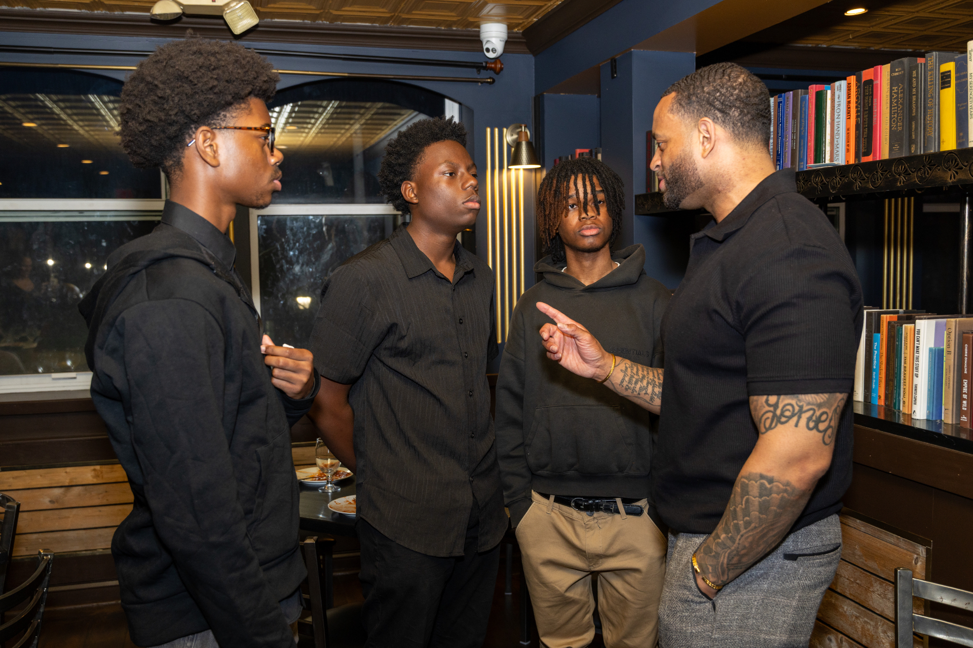 A mentor speaking with three young men in a mentorship setting